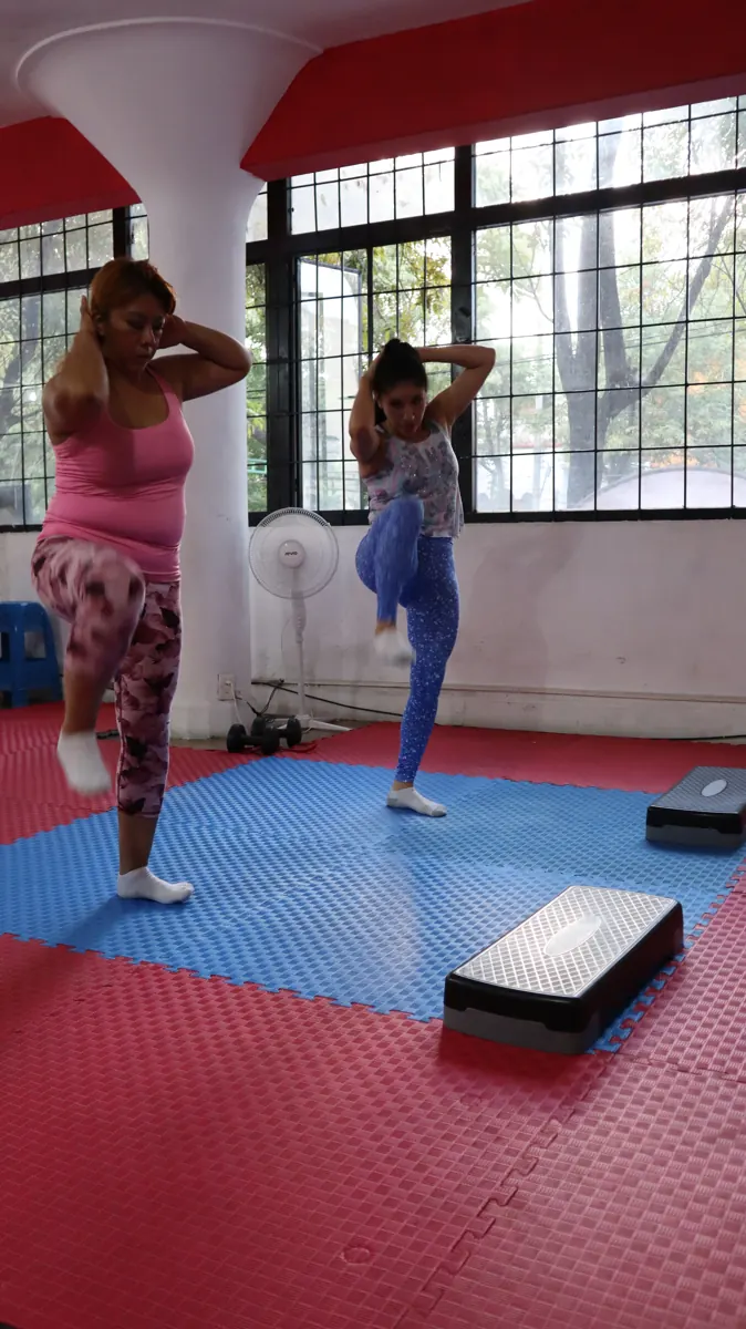 Alumnas haciendo ejercicio de rodillas al pecho en clase de Fitness Training